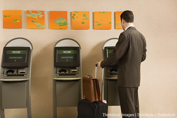 A photo shows a businessman using self-service kiosk