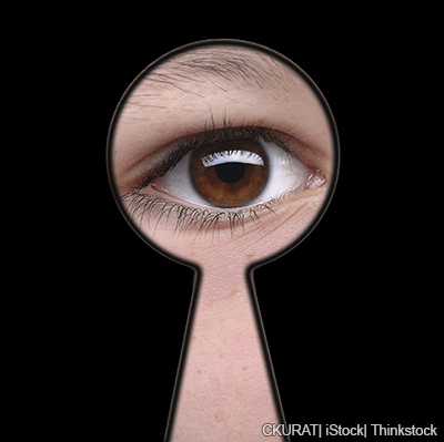 A photo of an eye looking through a keyhole